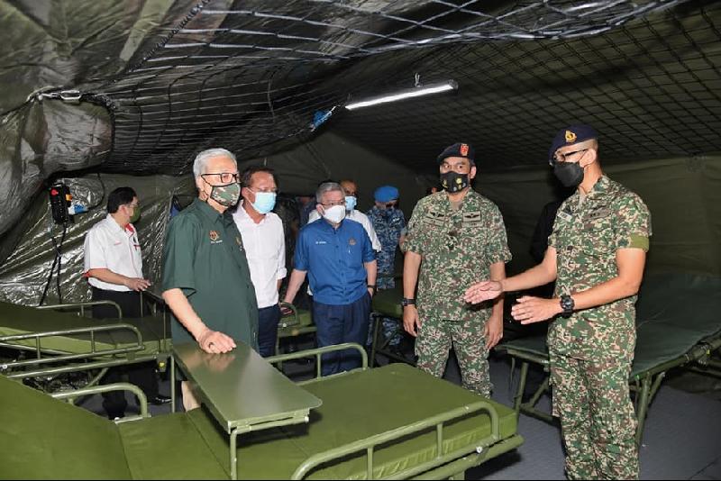 依斯迈沙比利（前排左一）参观野战医院内部时，聆听当局人员汇报进展。（取自大马国防卫队脸书专页）