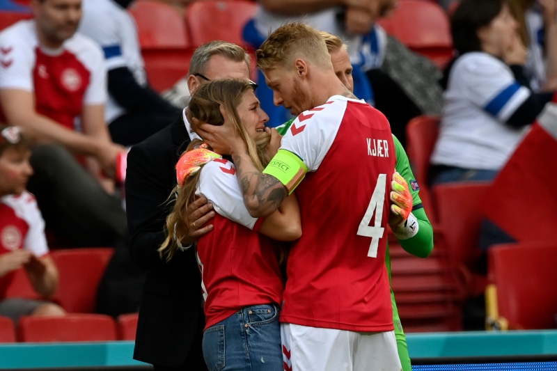 在得知埃里克森的妻子在场边焦急等待后，丹麦队长克亚尔（右二）与副队长卡斯帕.舒梅切尔（右一）上前拥抱她安慰她。（美联社照片）