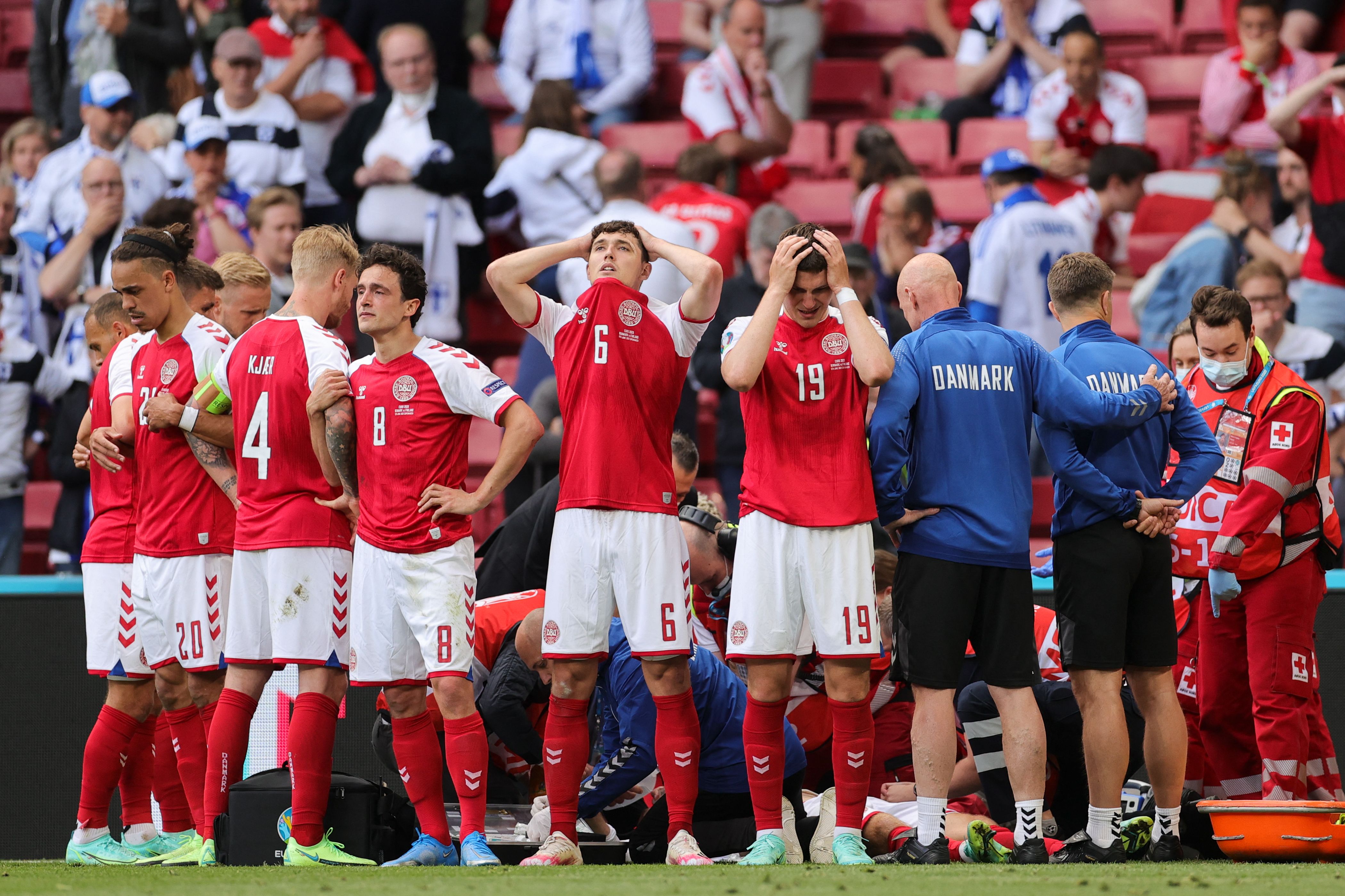 丹麦中场埃里克森在球场倒下后，医护人员紧急抢救，队友们开始哭泣，但仍心连心围起来，留给埃里克森隐私，也集气为他祈福。（法新社照片）