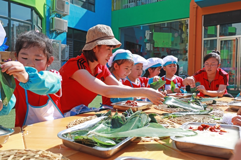 河北省唐山市滦南县第二幼儿园小朋友在老师指导下学习包粽子。让幼儿了解端午节来历和习俗，感受中国传统文化魅力。