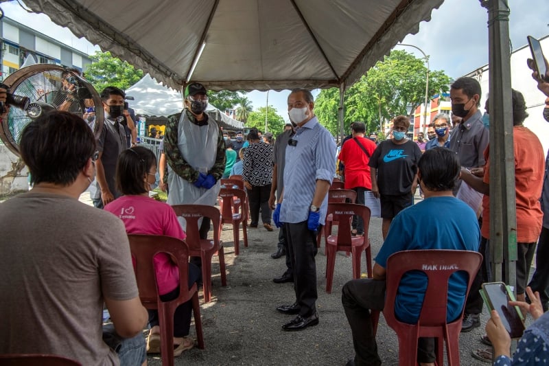 慕尤丁巡视敦拉萨镇的流动疫苗接种中心时，与等待进行冠病疫苗接种的当地民众会面。