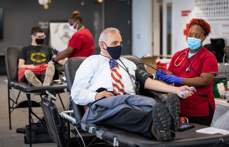 两名献血志愿者在献血站内测量血压后将开始捐血。（图：新华社）