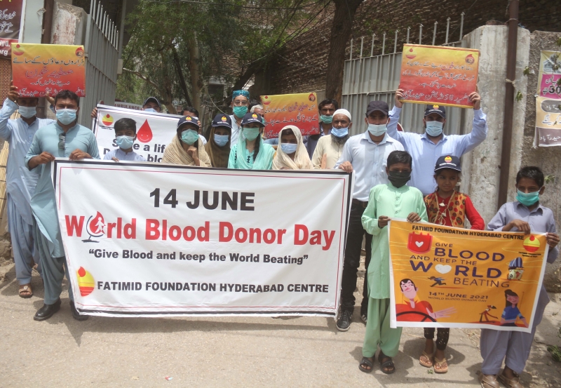 在巴基斯坦海得拉巴，人们举着横幅纪念世界捐血者日和呼吁民众参与捐血。（图：欧新社）