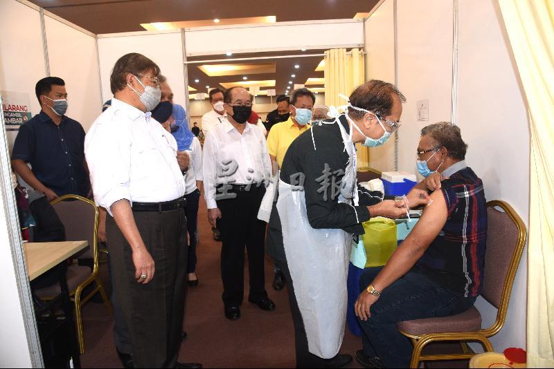 
砂首长阿邦佐哈里（左）观看医务人员为民众接种疫苗；左三起为砂副首长道格拉斯及砂地方政府及房屋部长沈桂贤。