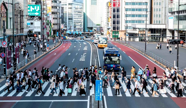 People cross a street outside Shinjuku train station in Tokyo. AFP