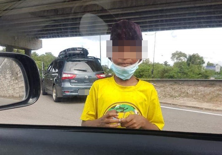 网民分享的照片显示，向驾驶人士行乞的男童当时也没有把口罩戴好，暴露在冠病毒感染风险中。(图片来自网民分享)