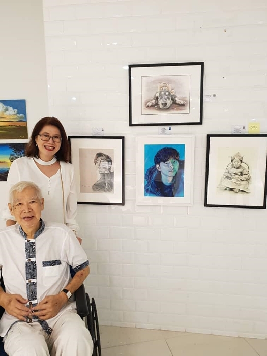 林静娴于2019年参与一场画展时，与父亲在自己的作品前合照。