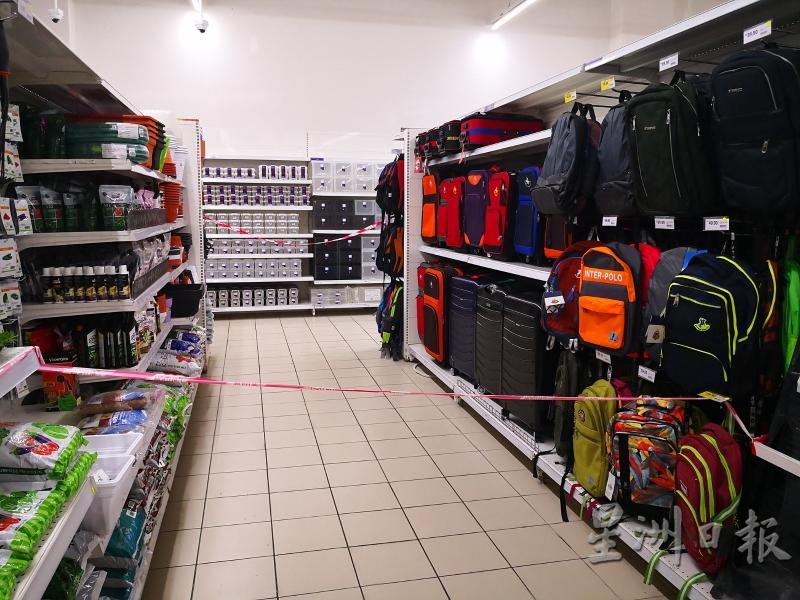 超市员工以警戒线封锁非必需品以外的区域。