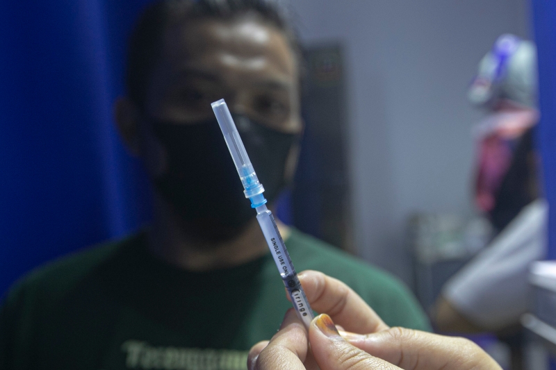 医护人员向接种者展示疫苗。