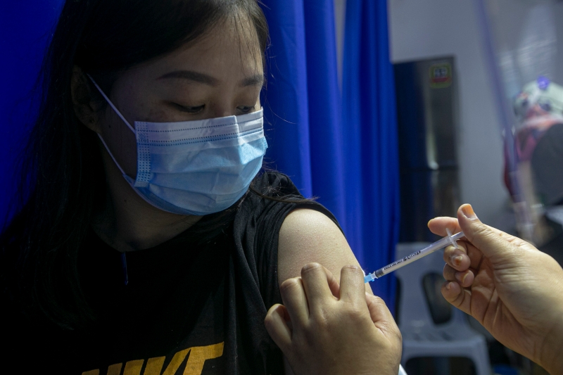 医护人员在为一名女性进行注射疫苗。