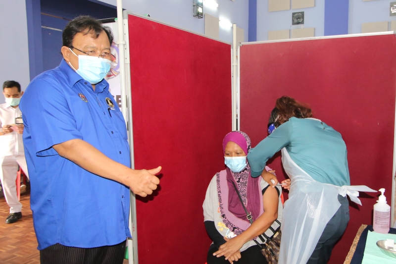 伊丁沙兹里（左）为一名正在接种疫苗的民众加油打气。