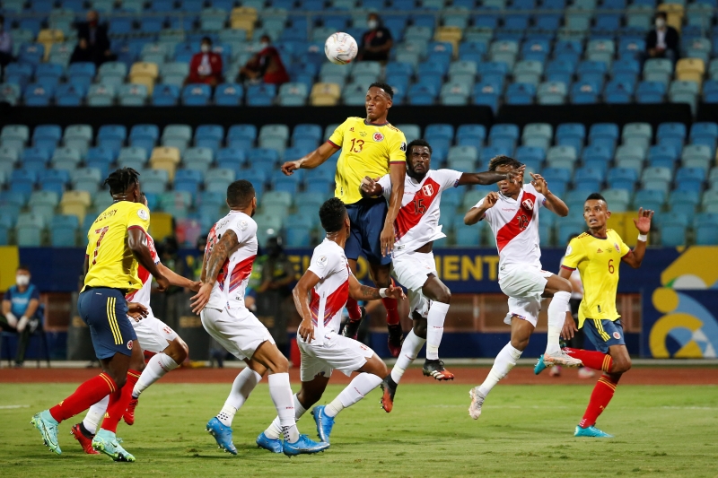 哥伦比亚后卫耶里米纳（中）下半场制造的乌龙球，让秘鲁队最终以2比1打败哥伦比亚迎来首胜。（欧新社照片）