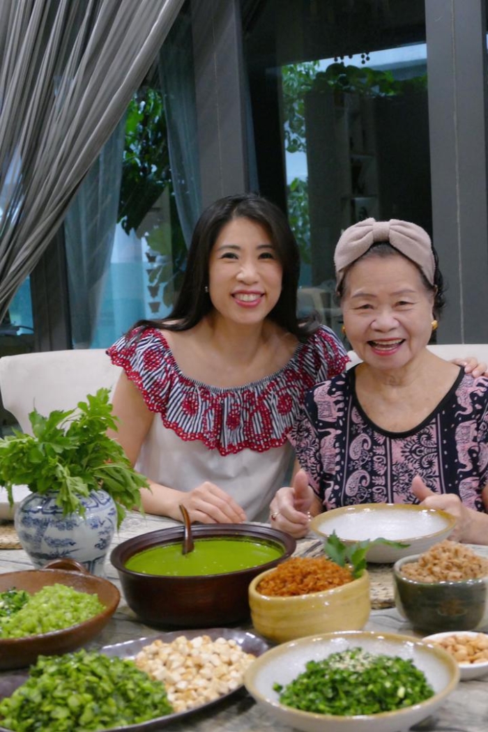 丘诗梅（左）与母亲刘秀花烹煮河婆擂茶，而河婆擂茶是他们在欢庆农历新年时必吃的食物。