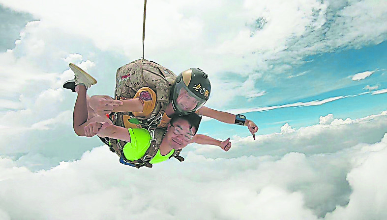 邓子浩（上）作为跳伞教练带着客户完成双人跳伞。
