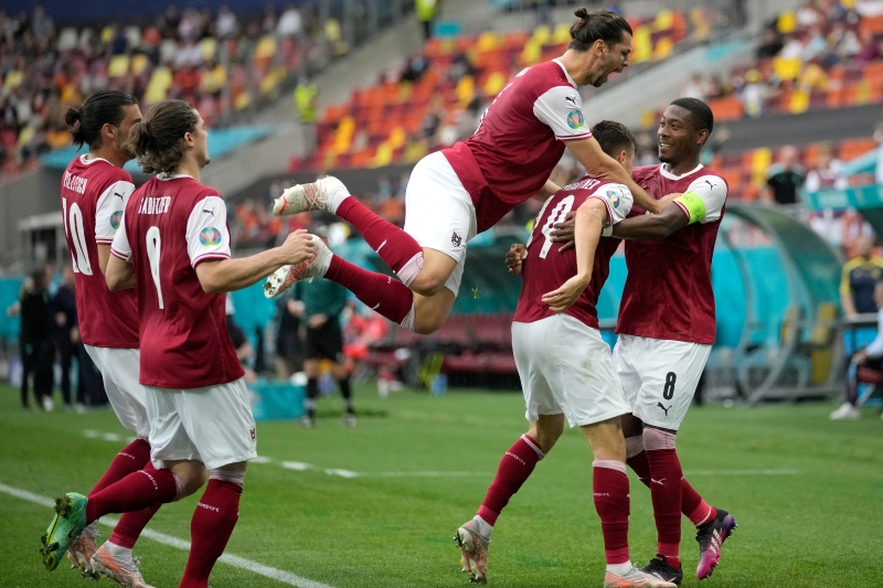 阿拉巴（右起）角球助攻鲍姆加特纳打入制胜进球，助奥地利以1比0击败乌克兰，队史首次晋级欧洲杯淘汰赛，两人在破门后与队友激动庆祝。（美联社照片）