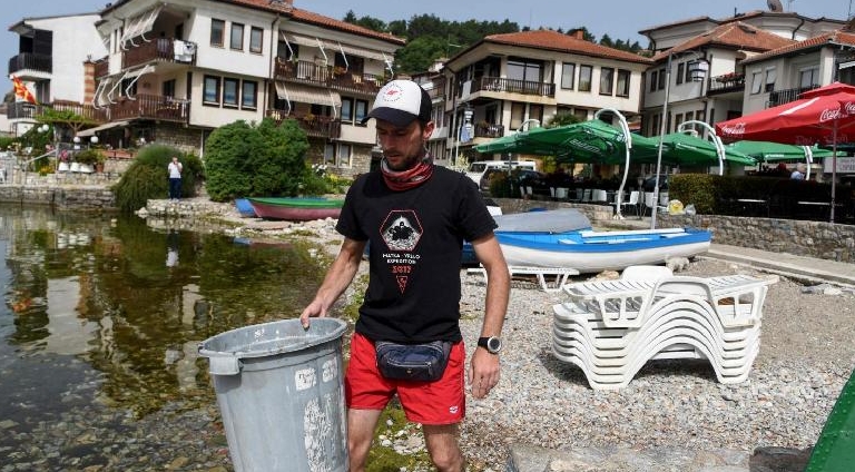 Archaeologist Nikola Paskali collects waste from the beach in Ohrid. AFP