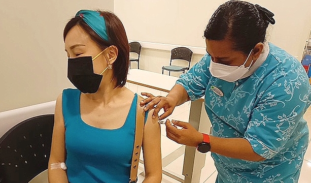A medical staff is giving the first injection to a volunteer participating in the COVID-19 vaccine clinical trial.