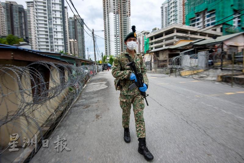 军警在吉隆坡一处实施”加强行动管制令“的地区执勤。　　　 新华社（张纹综摄）