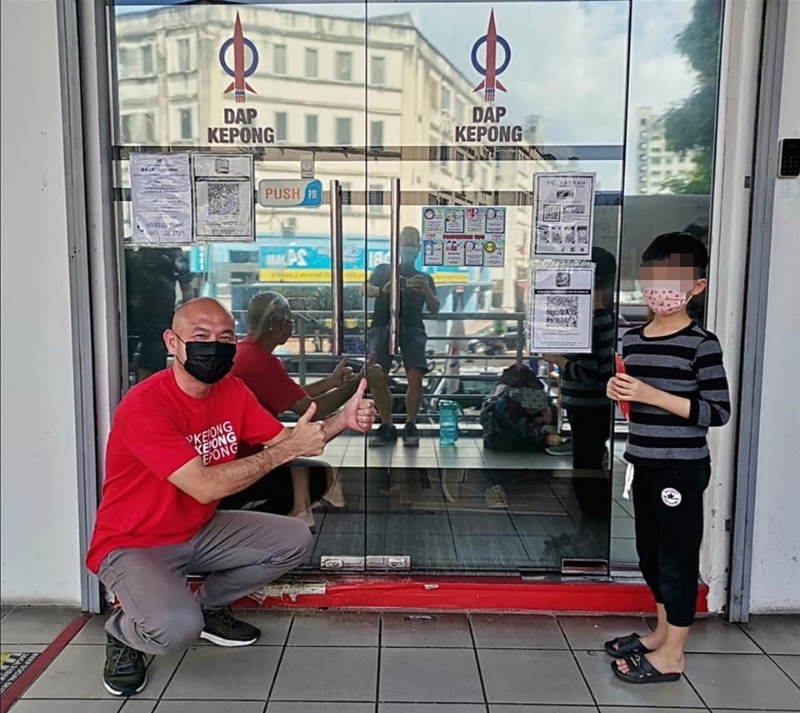 小男孩（右）决定捐出自己的红包钱，以帮助社会有需要的人士。左为林立迎。（照片取自甲洞行动小组脸书）