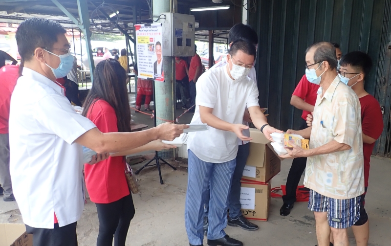倪可敏（中）派送盒饭予居民，左一是太平区国会议员郑国霖。