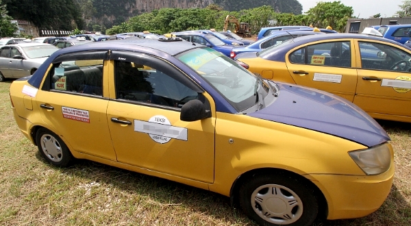 Various types of vehicles previously used as airport taxis are up for sale.