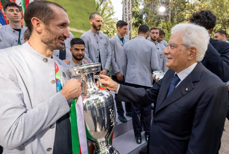 意大利足球队出席意大利总统马塔雷拉（右）举办的招待会，图为手持德劳内杯的基耶利尼与马塔雷拉相见欢。（法新社照片）