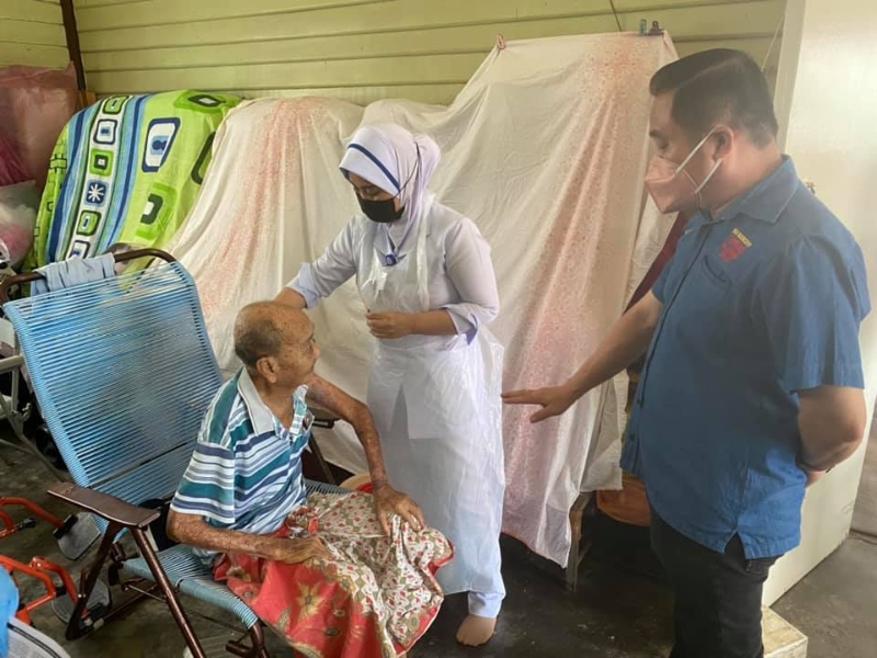 沙白安南县卫生局医护团队亲自上门为适耕庄新村的行动不便者接种疫苗。右为黄瑞林。