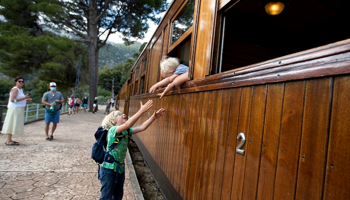 Two boys joke during a stopover of the Palma-Soller train in the Spanish Balearic Island of Mallorca. AFP