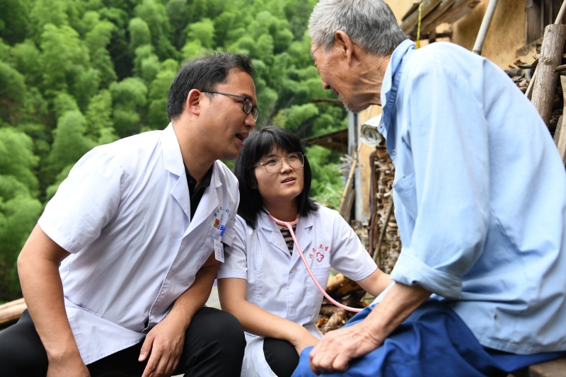 徐晓婵（中）和张建明来到清溪村了解一名重点病人的病情。