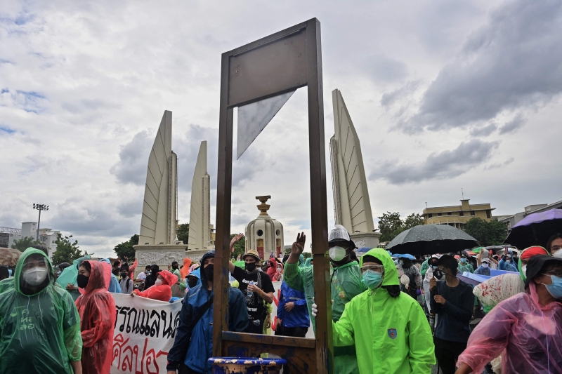 示威群众在民主纪念碑前展示断头台模型。（法新社图片）