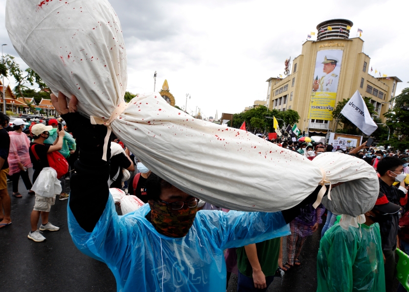 示威群众高举模拟冠病死者的裹尸袋参与游行，以宣泄不满。 （欧新社图片）