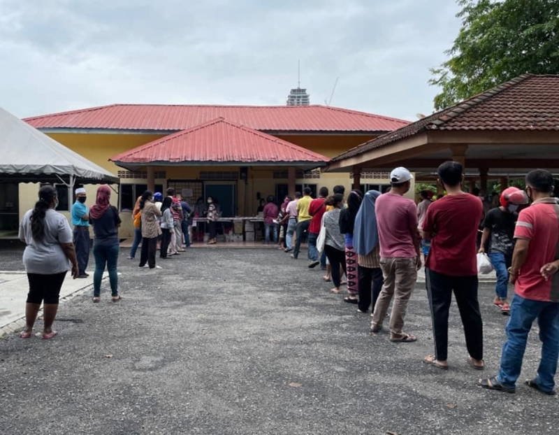民众早前在帝沙泗岩沫花园社区礼堂外排队等候领取食物库的物资。
