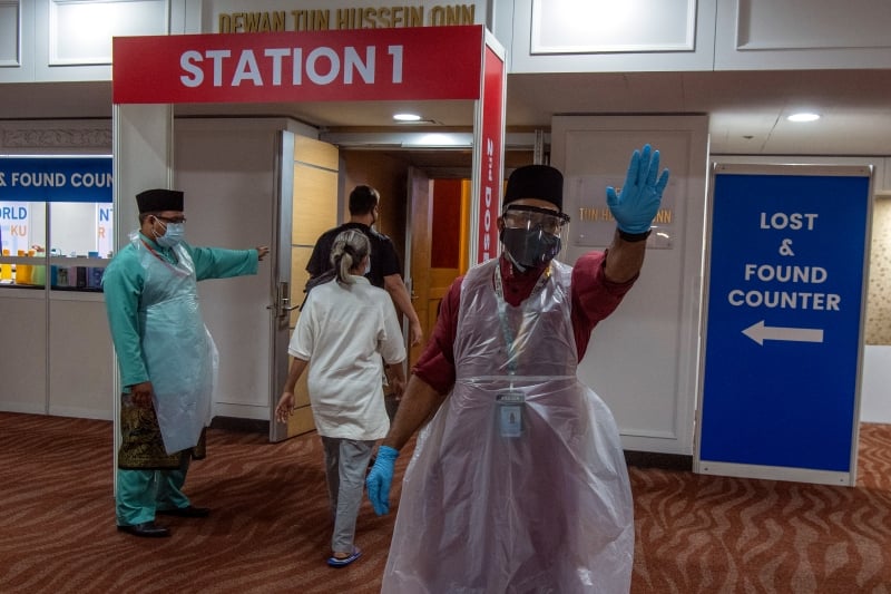 在疫苗中心的医护人员都穿上漂亮马来服装 ,为前来接种者服务 。