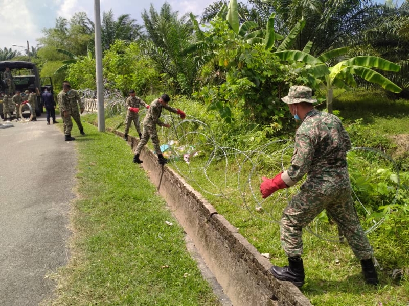 军人帮助修复铁蒺藜网。