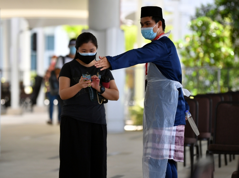 在Mega Movenpick 酒店的疫苗接种中心，义工穿著一身马来传统服装为市民服务。