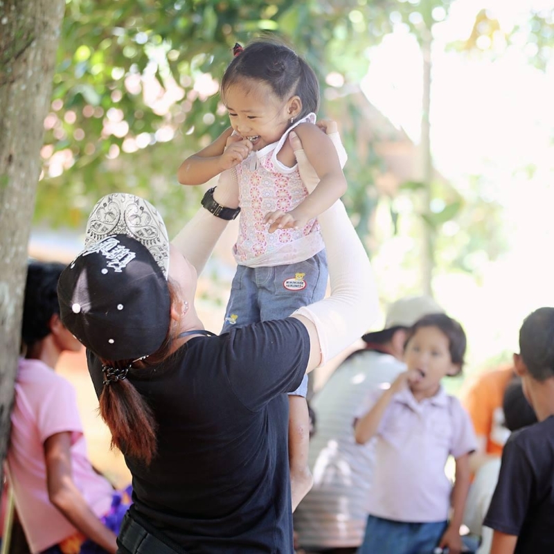 孩子的快乐很简单，张惠芯轻轻地将女童举起，她就眉开眼笑了。