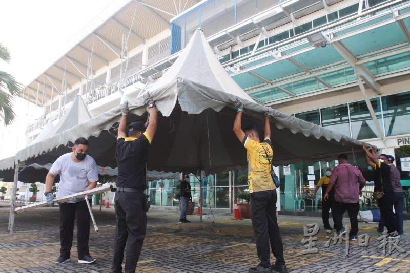 工作人员为周五在槟岛市政厅体育馆进行的冠病筛检活动，做好准备。