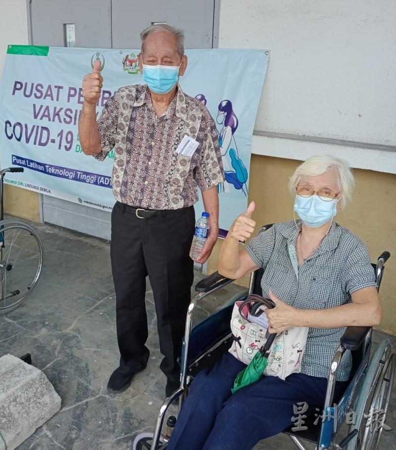 萧文辉（左）及蔡亚娘在接种疫苗后，竖起姆指赞好。