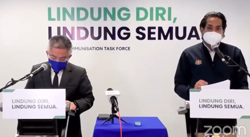 凯里（右）宣布允许民众接种时录影。左为阿汉峇峇。