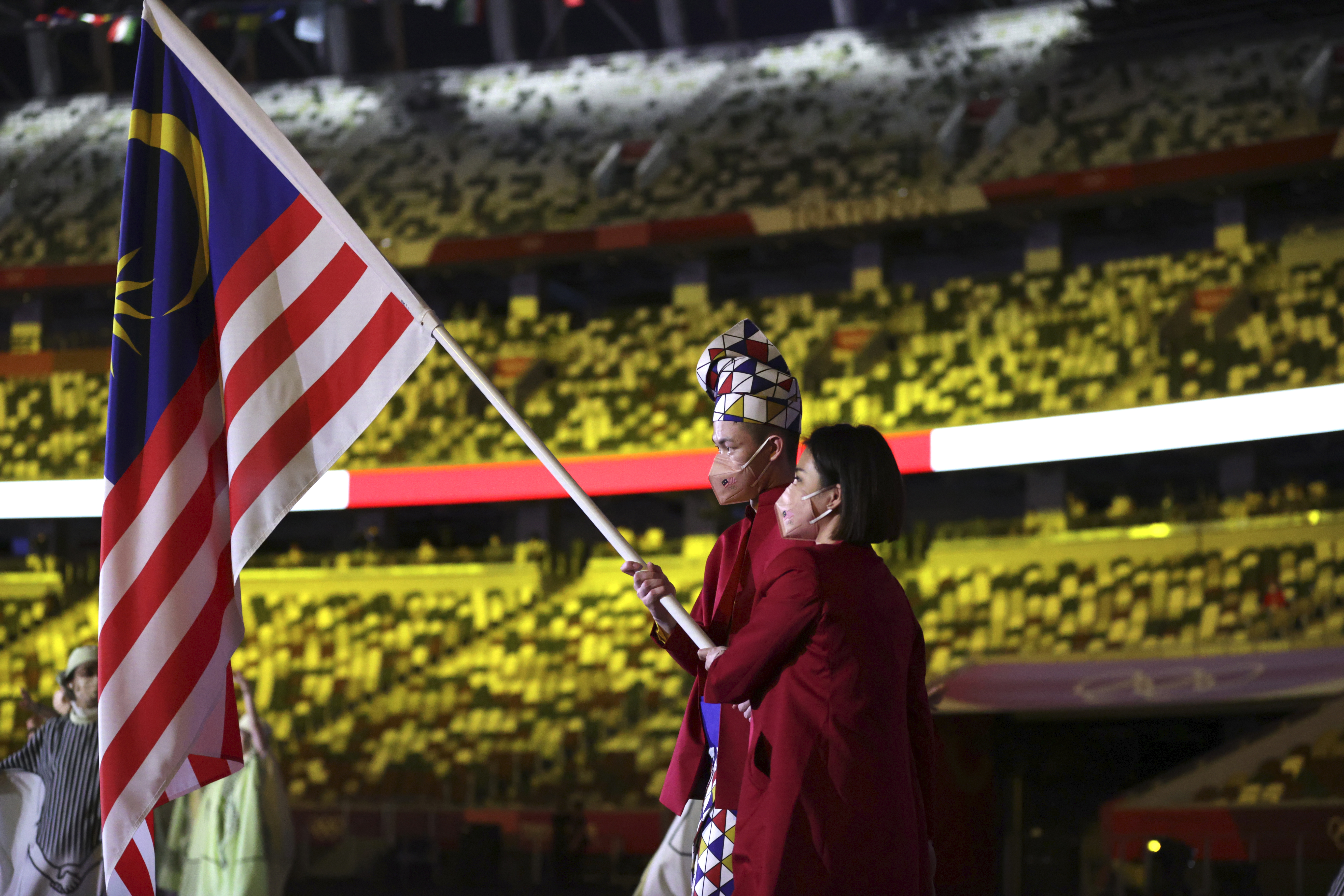 李梓嘉（左）与吴柳萤以双旗手在东京奥运开幕式上，一起挥舞着国旗辉煌条纹出场。（美联社照片）