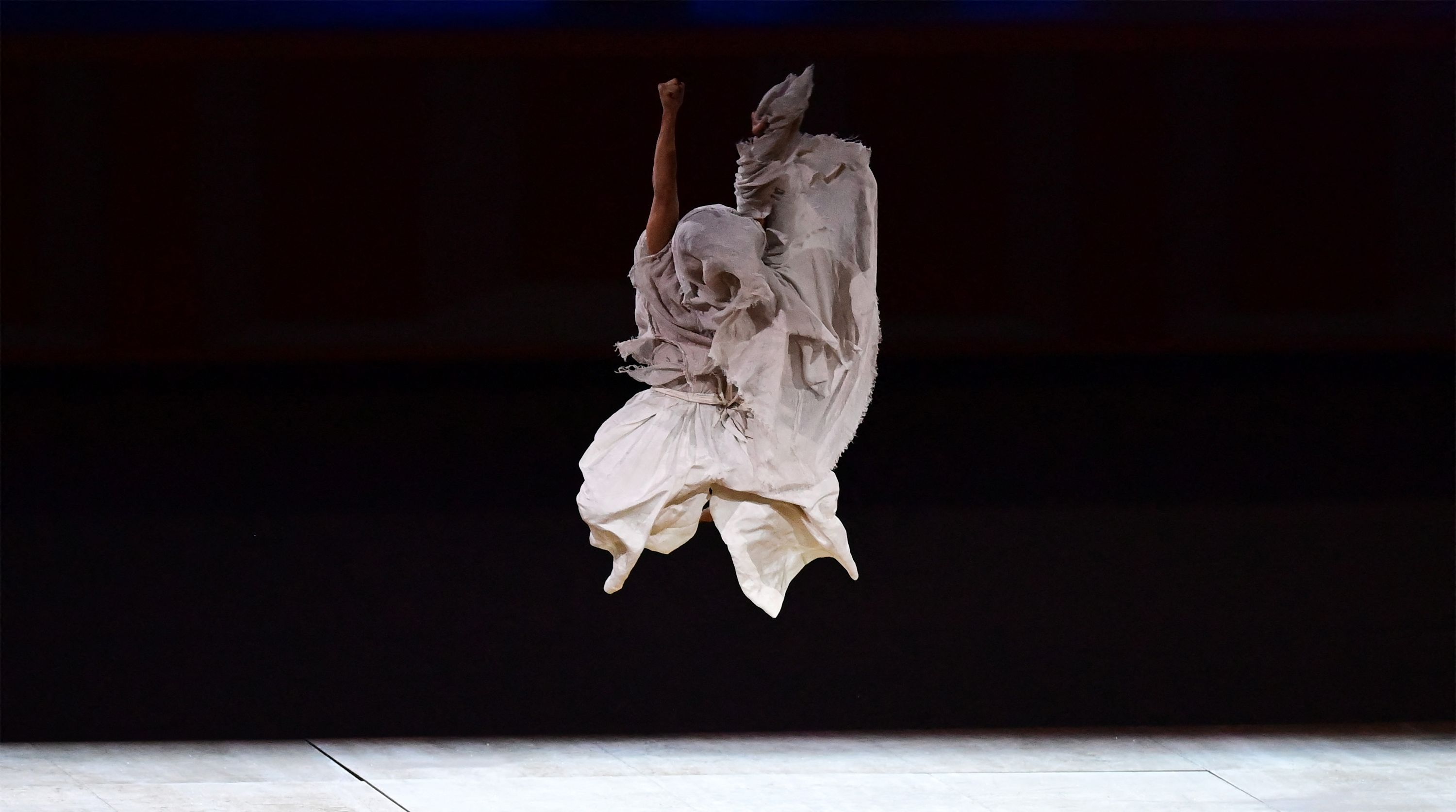 日本著名男舞蹈家森山未来献上表演，纪念疫情中丧生的人，会场众人肃立默哀。（法新社照片）