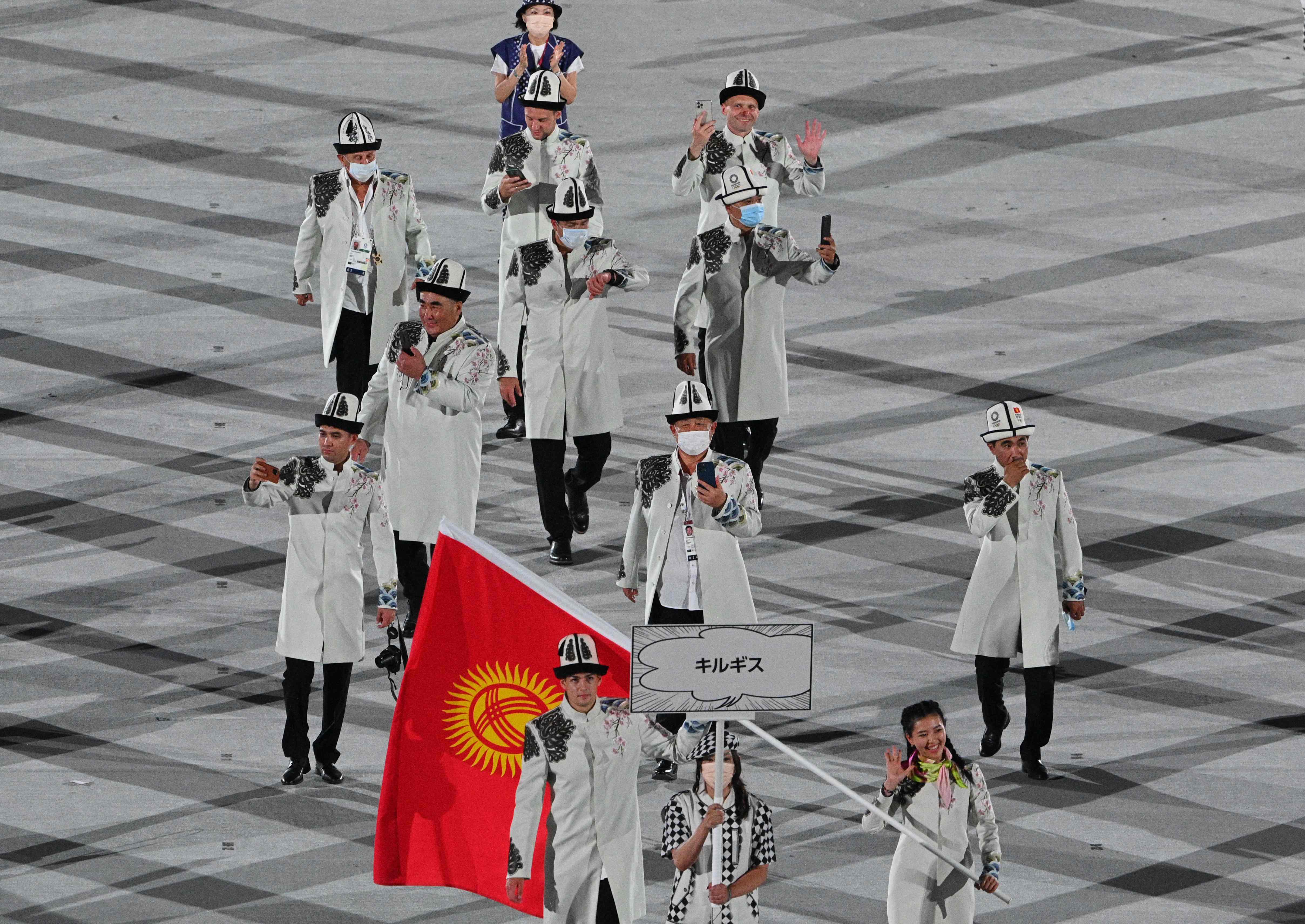 吉尔吉斯斯坦代表团在东京奥运开幕式上亮相时，多人没戴口罩。（法新社照片）

