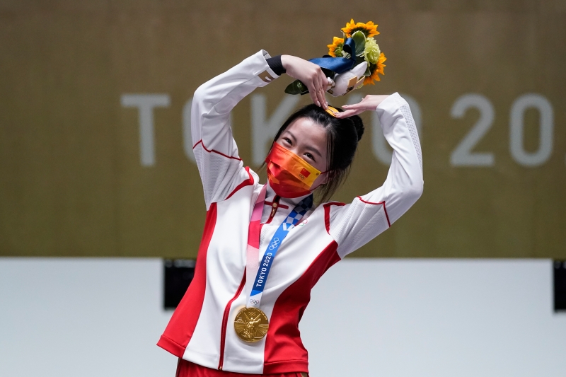 夺下东京奥运会首金的中国射击选手杨倩在领奖台上比心。（美联社照片）