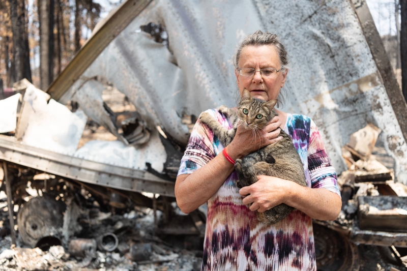 幸存的灾区居民和她的宠物猫站在一片废墟当中。（法新社图片）