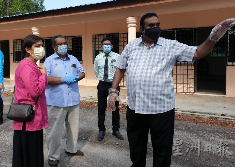 拉威（右一）连同卫生县属官员巡视乌达玛花园临时接种中心环境。