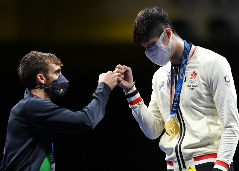 男子个人花剑金牌获得者中国香港选手张家朗（右）与银牌获得者意大利选手加罗佐击拳致意。（新华社照片）