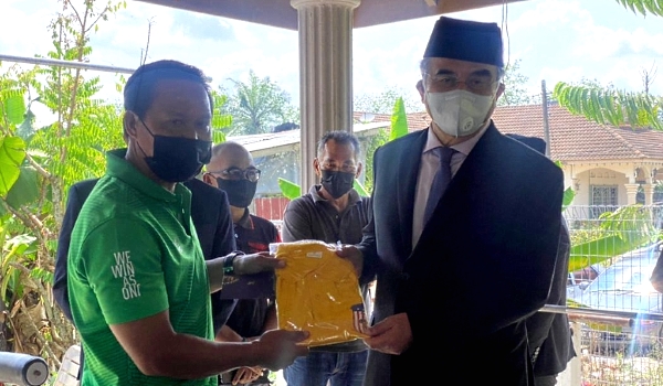Ahamd Janius (L) presenting a souvenir to Tun Mohd Ali Rustam, the Yang di-Pertua Negeri who visited the garage.