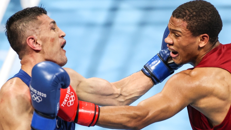 在东京奥运会拳击男子69公斤级八分之一比赛中，乌兹别克斯坦选手巴图罗夫（蓝衣）战胜多米尼加选手波兰科·埃米利亚诺。（新华社照片）