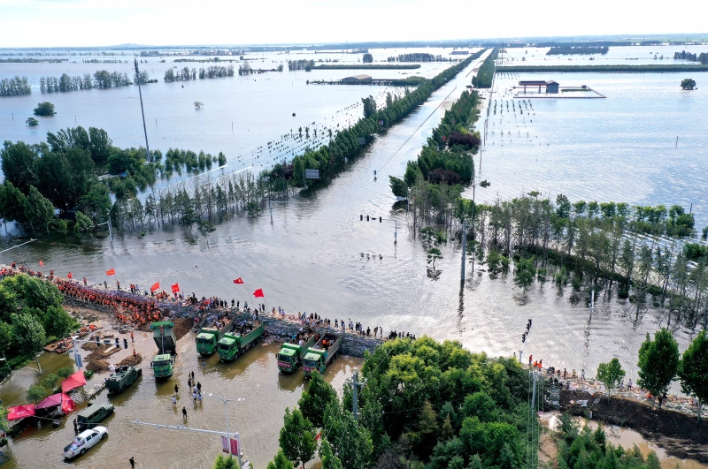 在浚县傅庄堤上，救援人员和群众一起填装沙袋，加固大堤为浚县县城及26个村庄提供保护。（无人机照片）


