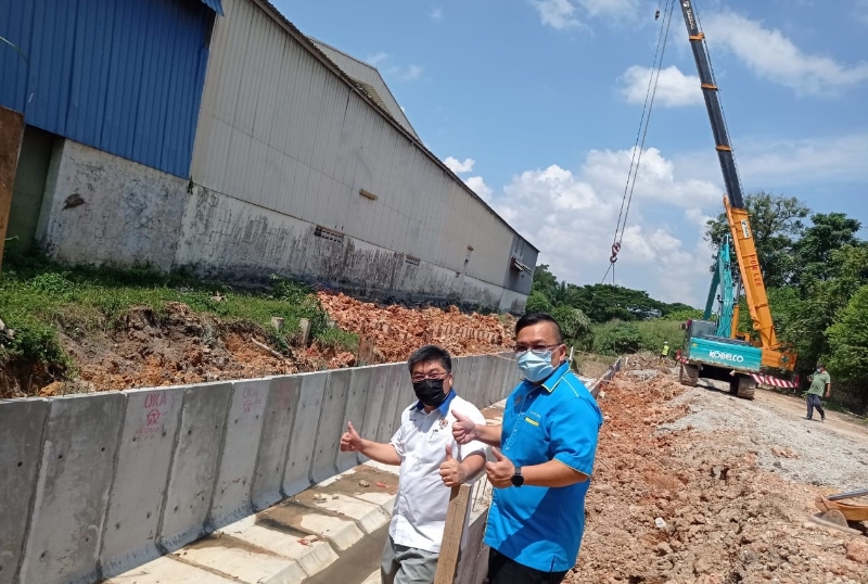 陈午峤（左）在曾友盛的陪同下，巡视烈光镇工业区排水沟渠工程进展。